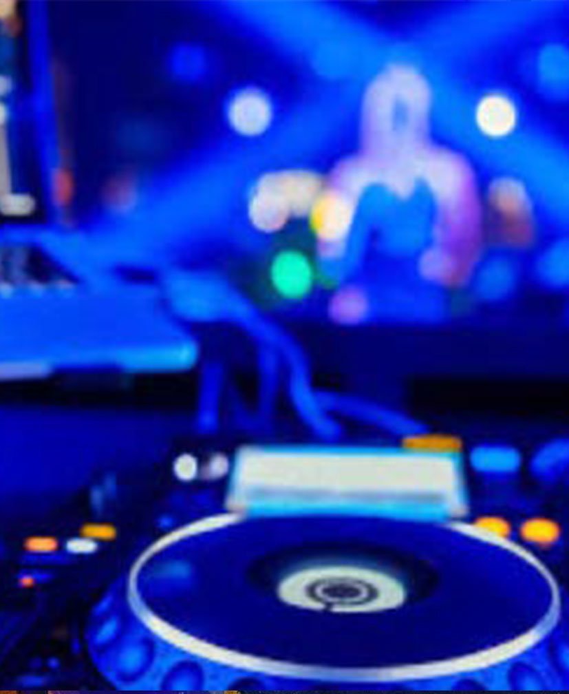 Wedding DJ booth with decks and lighting at an evening reception
