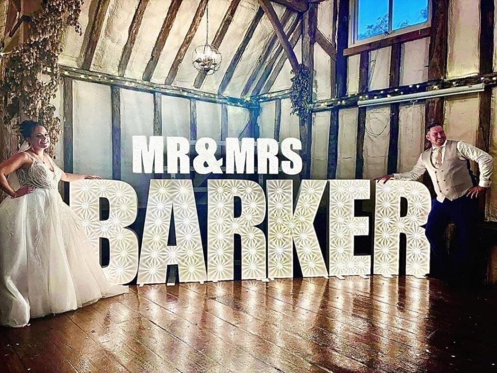 Couple with giant MR & MRS illuminated surname at Winters Barns